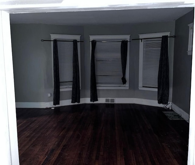 empty room with dark wood-type flooring