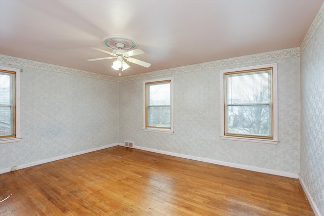 spare room with ceiling fan, light hardwood / wood-style flooring, and a wealth of natural light