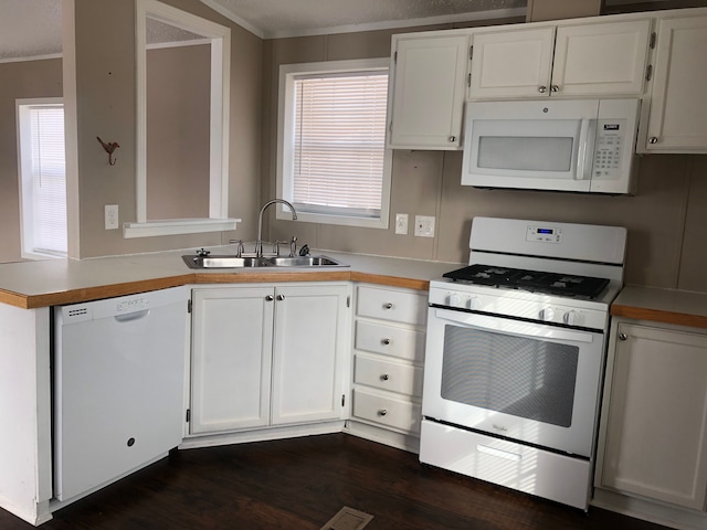 kitchen with crown molding, sink, white cabinets, and white appliances