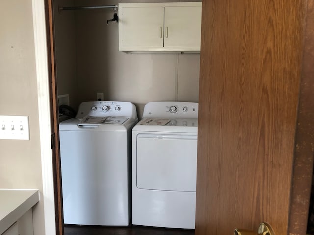 clothes washing area featuring washing machine and dryer and cabinets