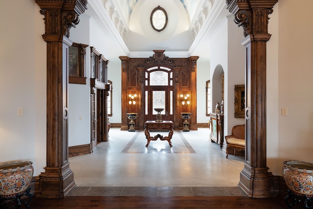 interior space with decorative columns, crown molding, and a high ceiling