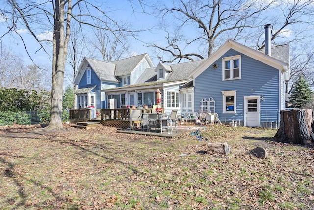 rear view of property featuring a deck and a chimney