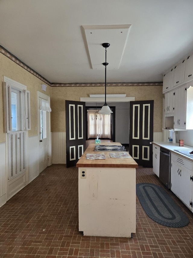 kitchen with white cabinets, wainscoting, wooden counters, and appliances with stainless steel finishes