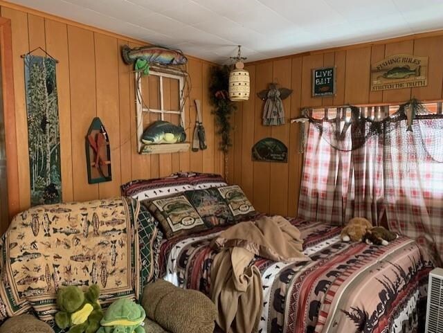 bedroom featuring wooden walls
