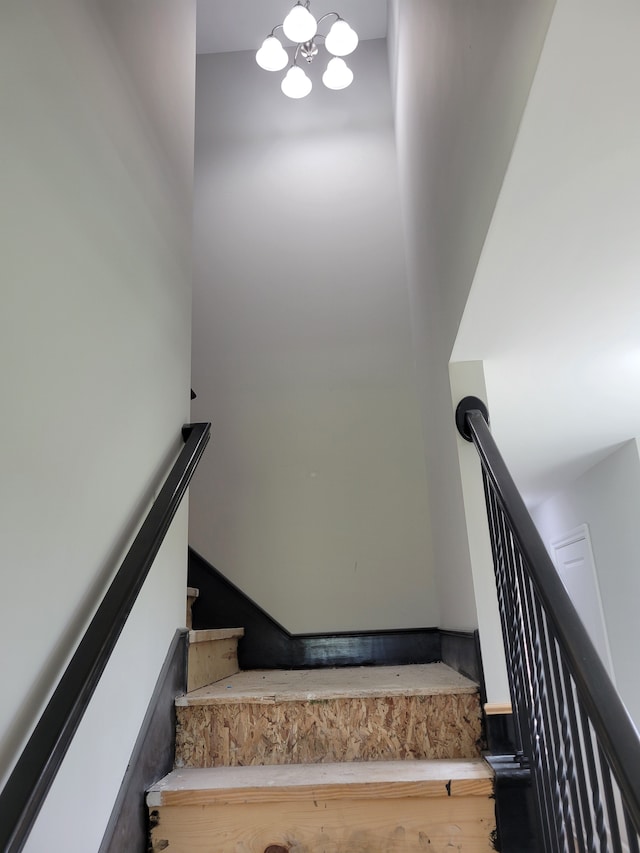 stairway featuring an inviting chandelier