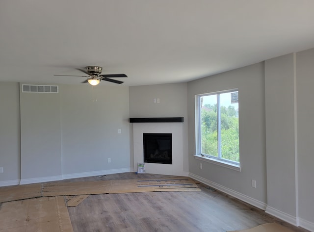 unfurnished living room with ceiling fan