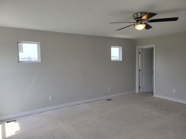 unfurnished room with ceiling fan and a healthy amount of sunlight