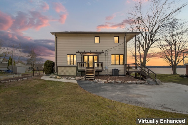 view of front of property with a lawn, a pergola, central air condition unit, and a wooden deck