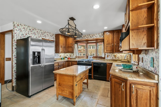 kitchen with black appliances, a kitchen island, light stone counters, and sink