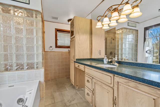 bathroom with vanity, a bathtub, and tile walls