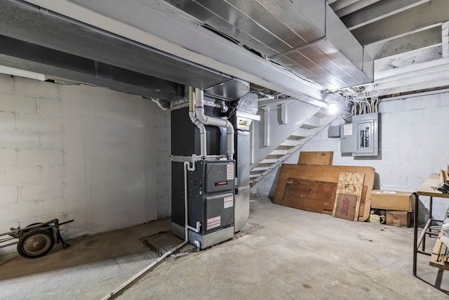 basement featuring electric panel and heating unit