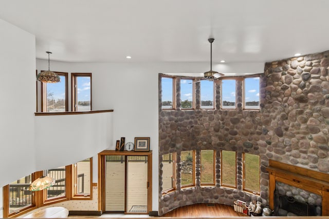 living room with ceiling fan, a fireplace, a healthy amount of sunlight, and hardwood / wood-style flooring