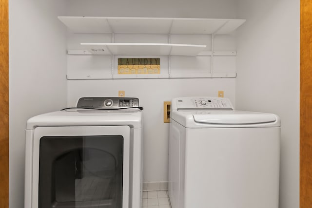 washroom with washing machine and clothes dryer and light tile patterned floors