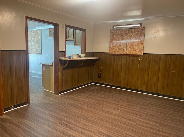 kitchen featuring dark hardwood / wood-style floors, crown molding, and wood walls