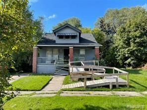 bungalow-style home with a porch and a front lawn