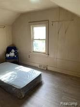 bonus room with hardwood / wood-style flooring and vaulted ceiling