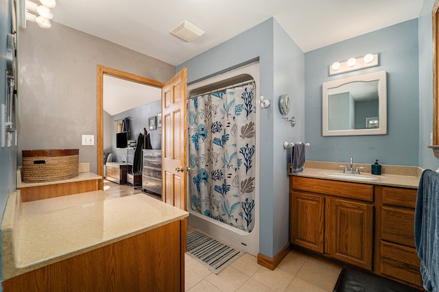 bathroom featuring tile patterned flooring, vanity, and walk in shower