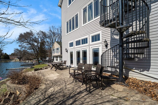 view of patio featuring a balcony and a water view