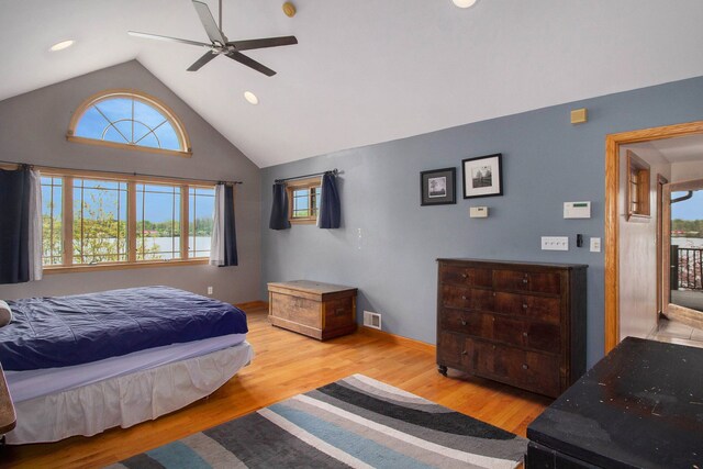 bedroom with ceiling fan, light hardwood / wood-style floors, high vaulted ceiling, and multiple windows