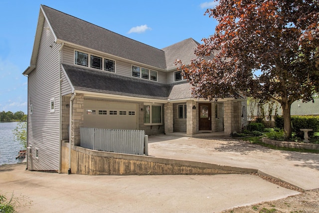 view of front of house featuring a garage and a water view