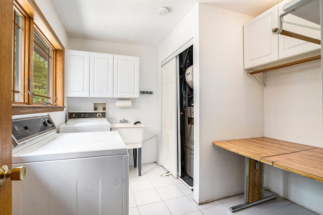 laundry room with cabinets, light tile patterned floors, and washing machine and dryer