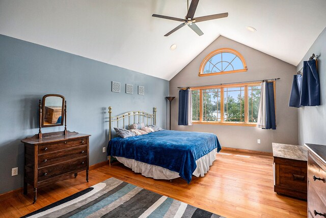 bedroom with ceiling fan, light wood-type flooring, and high vaulted ceiling