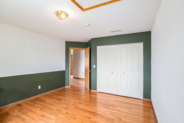 unfurnished bedroom featuring light hardwood / wood-style floors and a closet