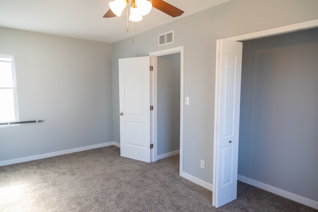 unfurnished bedroom featuring ceiling fan, dark carpet, and a closet