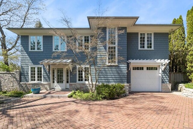 49106 Sun Valley Falls Blvd, New Buffalo, MI 49117 - back of house featuring stone siding, decorative driveway, and a garage