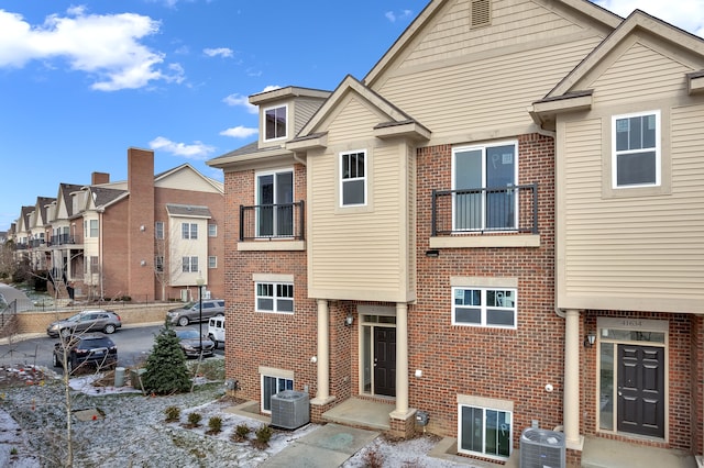 view of front of property with a balcony and central AC