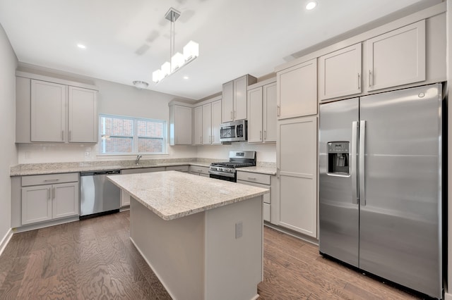 kitchen featuring decorative light fixtures, a center island, stainless steel appliances, and dark hardwood / wood-style floors