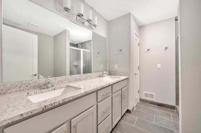 bathroom featuring tile patterned flooring, vanity, and a shower with door