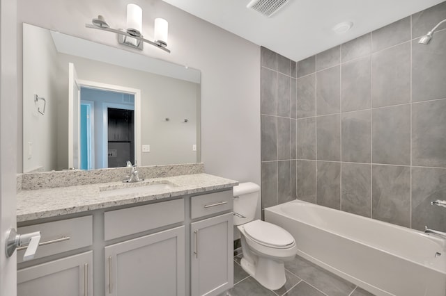 full bathroom with tile patterned floors, vanity, tiled shower / bath combo, and toilet