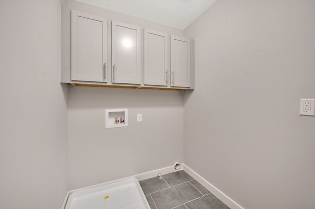 laundry room with cabinets, dark tile patterned flooring, and washer hookup