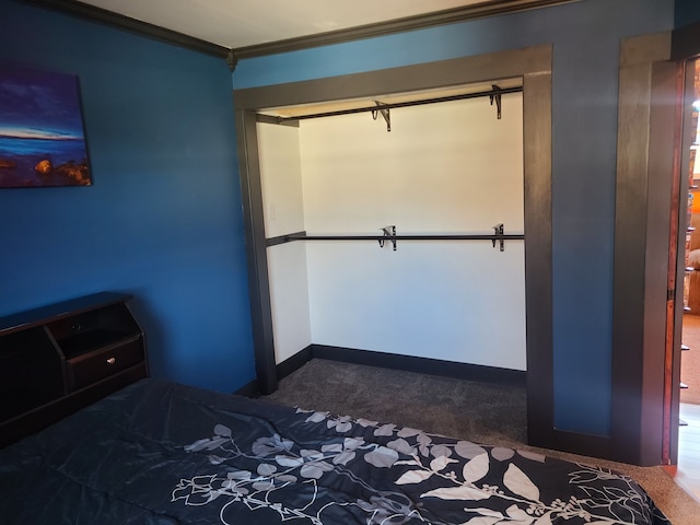 unfurnished bedroom featuring dark colored carpet, crown molding, and a closet