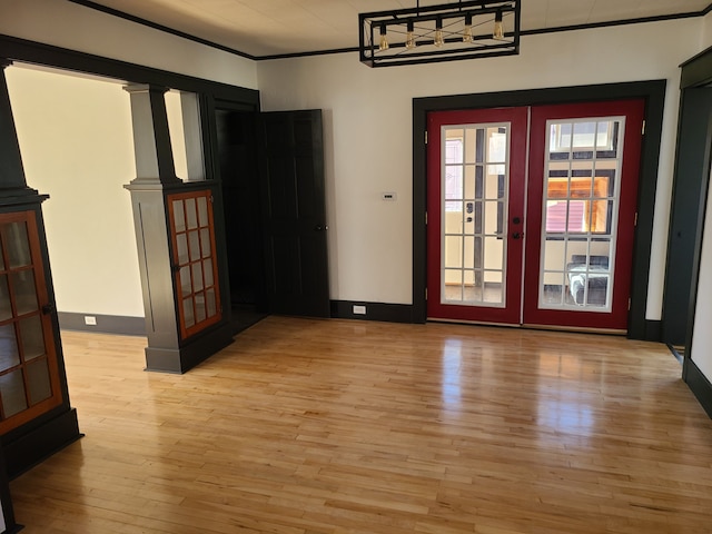 unfurnished room featuring crown molding, light hardwood / wood-style flooring, and french doors