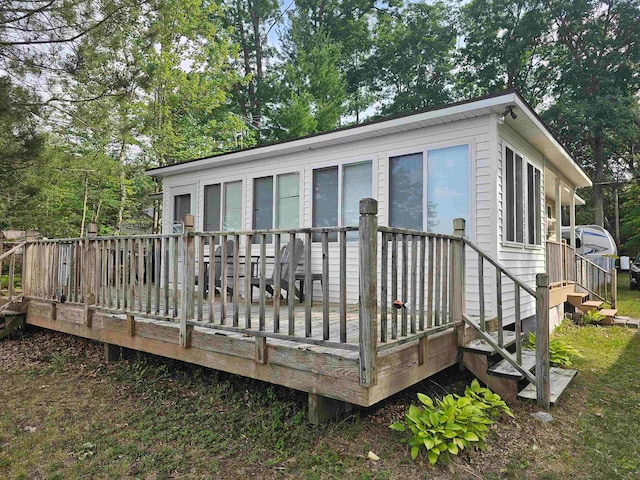 rear view of house featuring a wooden deck