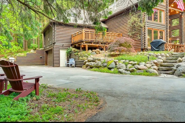 view of patio with area for grilling, a garage, and a wooden deck