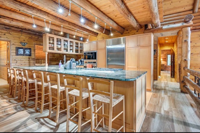 kitchen with light hardwood / wood-style flooring, built in appliances, beam ceiling, kitchen peninsula, and wood ceiling