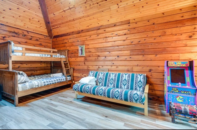 bedroom featuring light wood-type flooring and wood walls