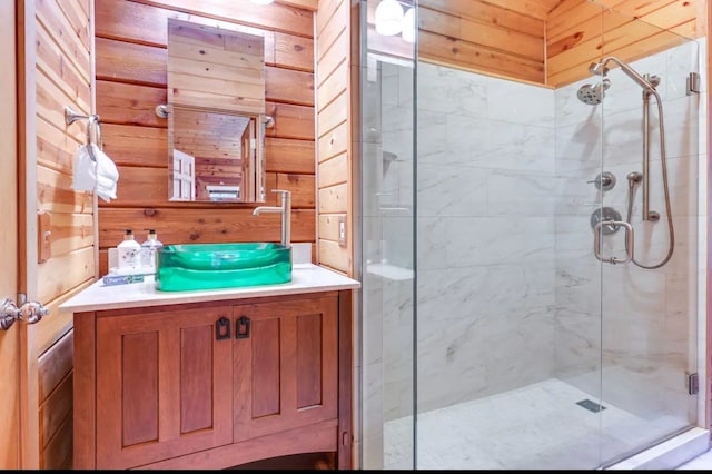 bathroom featuring wood walls, vanity, and a shower with shower door