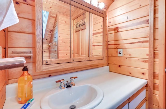 bathroom featuring vanity and wooden walls