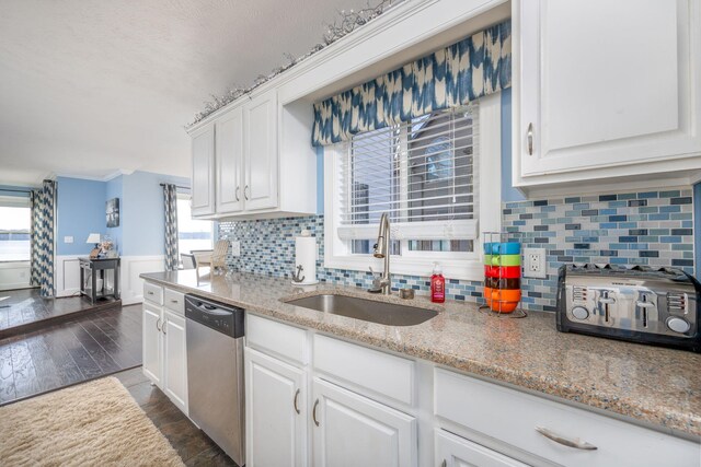 kitchen with sink, stainless steel dishwasher, dark hardwood / wood-style floors, decorative backsplash, and white cabinetry