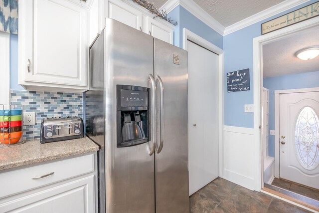 kitchen with decorative backsplash, stainless steel refrigerator with ice dispenser, a textured ceiling, crown molding, and white cabinetry