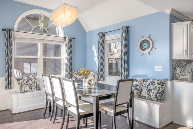 dining room featuring hardwood / wood-style floors, a chandelier, and vaulted ceiling