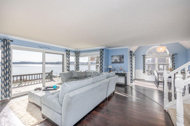 living room with a notable chandelier, dark hardwood / wood-style floors, a water view, and ornamental molding