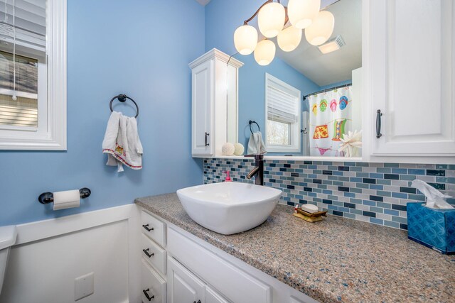 bathroom with vanity and tasteful backsplash