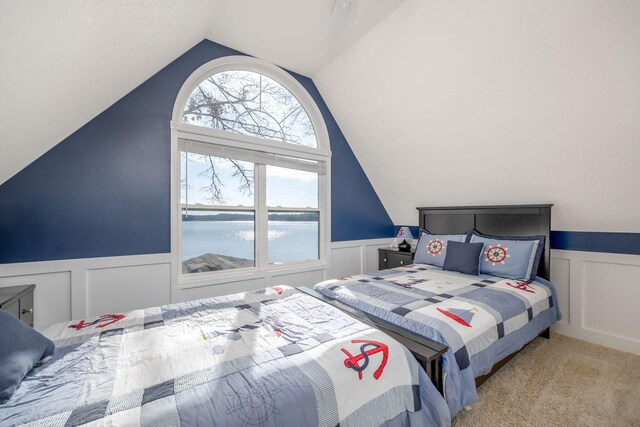 carpeted bedroom featuring a water view and lofted ceiling