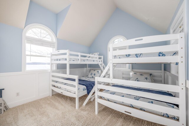 bedroom with light colored carpet and lofted ceiling