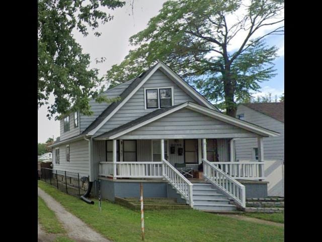 bungalow-style home with covered porch and a front lawn